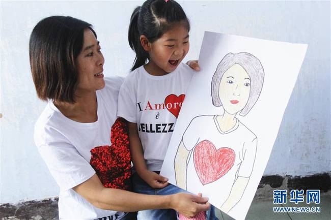 5月10日，在河北唐山市豐潤(rùn)區(qū)迎賓路幼兒園開(kāi)展的“媽媽?zhuān)覑?ài)你”主題活動(dòng)中，陳悅寧小朋友將自己的繪畫(huà)作品送給媽媽作為節(jié)日禮物。 新華社發(fā)（朱大勇 攝）