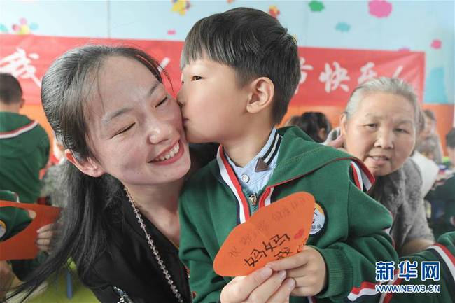 5月10日，在湖北省襄陽(yáng)市一家幼兒園舉辦的母親節(jié)主題活動(dòng)中，一名小朋友將自己制作的賀卡獻(xiàn)給媽媽。 新華社發(fā)（安富斌 攝）
