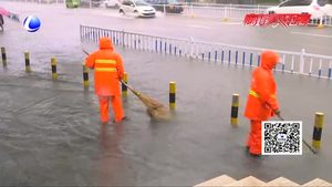 環(huán)衛(wèi)工人雨中清理水中垃圾 保障排水順暢