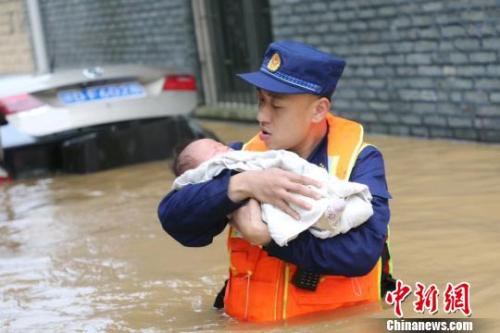 6月10日，江西省吉安縣梅塘鄉(xiāng)渡口村，消防員蹚著齊腰深的洪水，小心翼翼地將嬰兒轉(zhuǎn)移到安全地帶?！」逶?攝